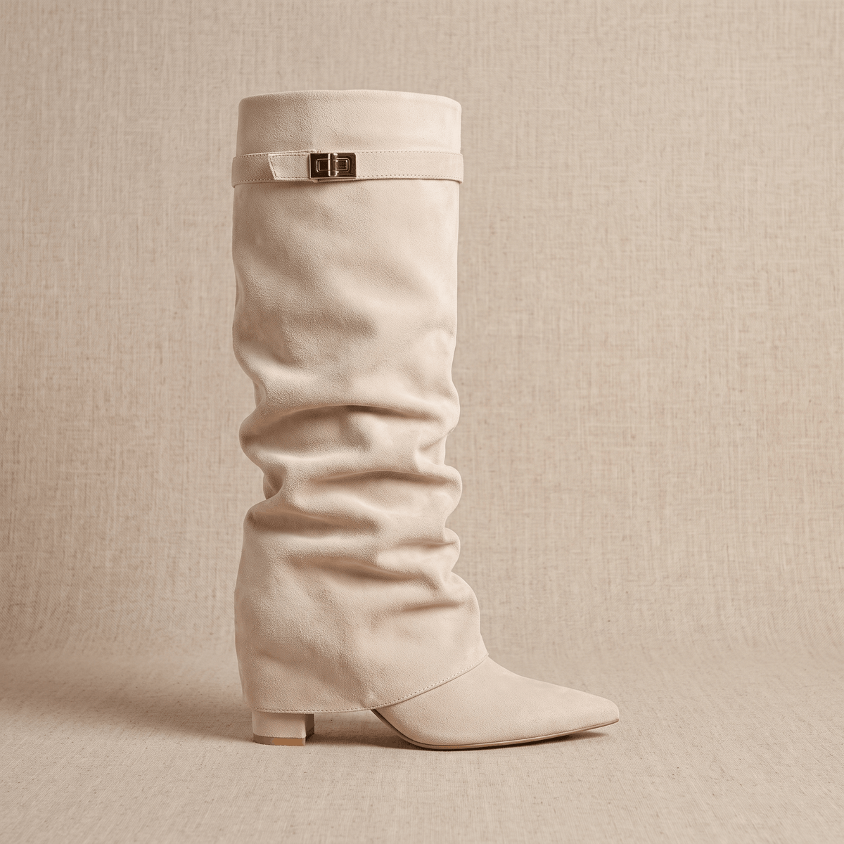 Beige slouchy fold-over boots shown from the front with pointed toes
