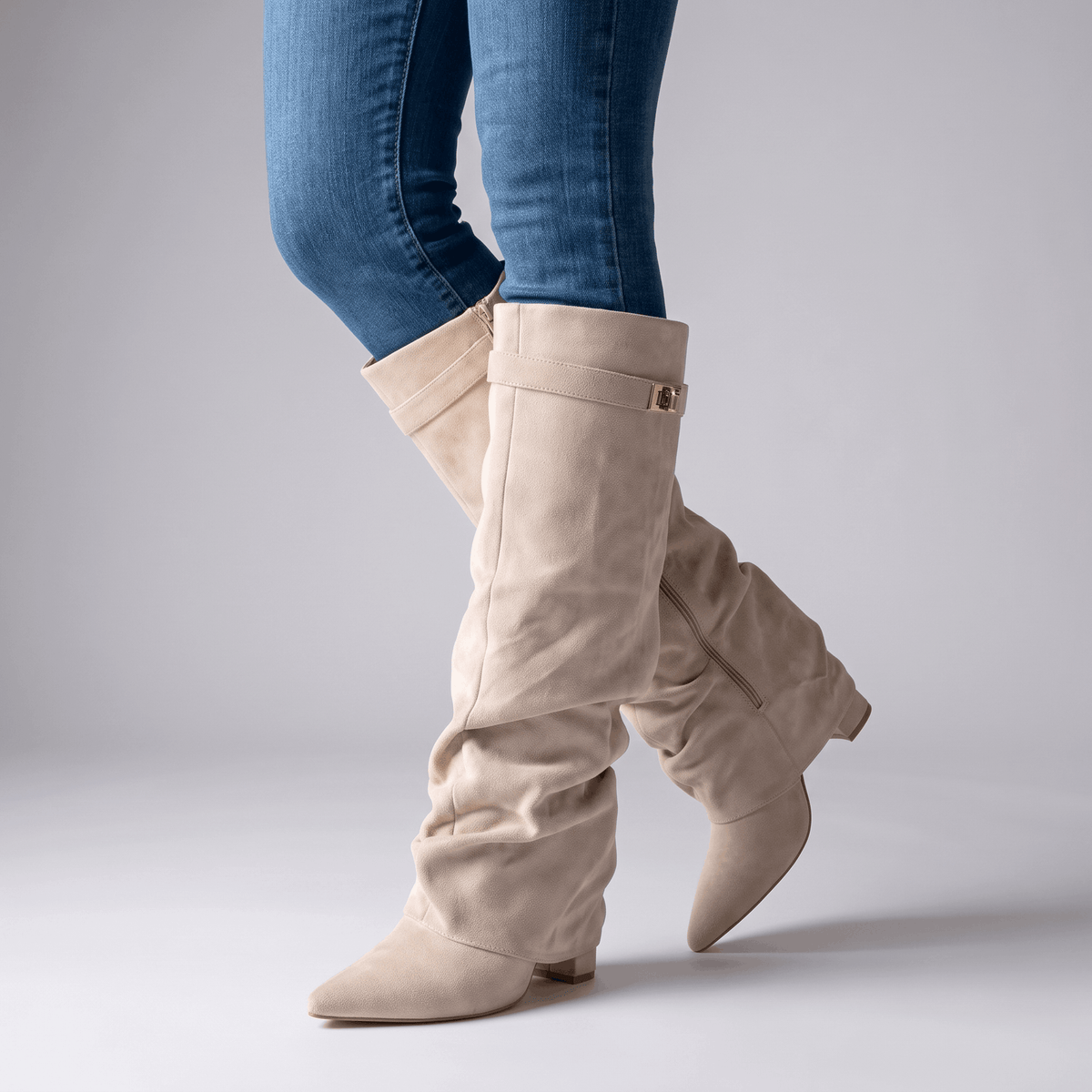 Beige fold-over boots worn with blue jeans, showing the slouchy knee-high shaft