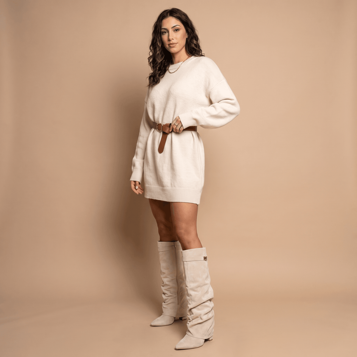 Beige slouchy fold-over boots worn by a female model in a cream dress
