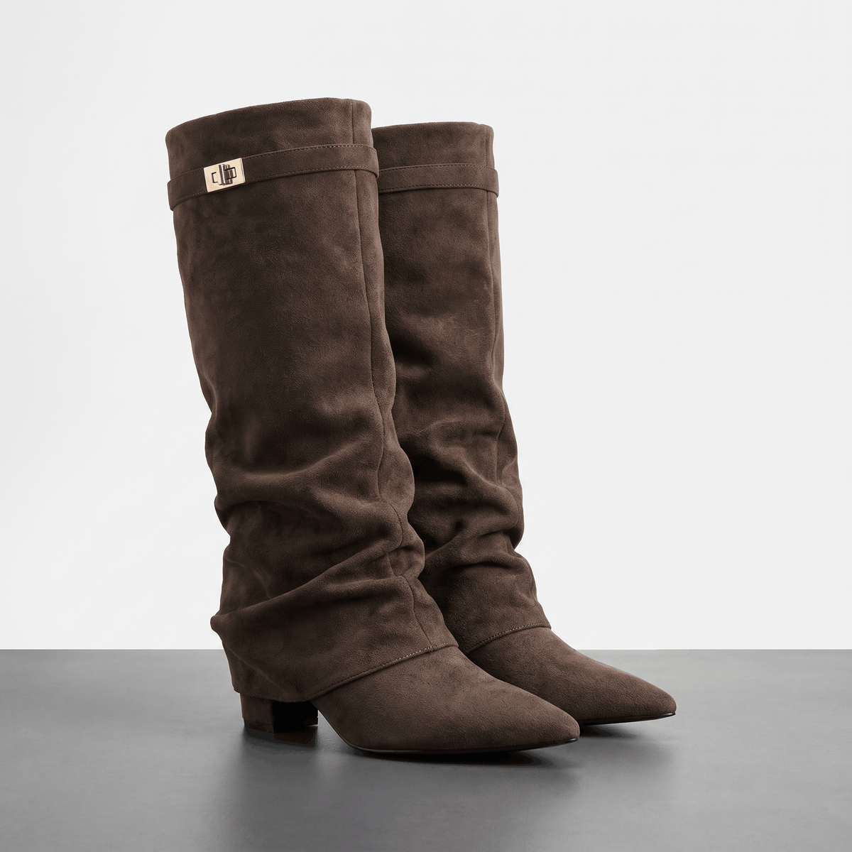 Dark brown slouchy fold-over knee-high boots with pointed toes and strap detail