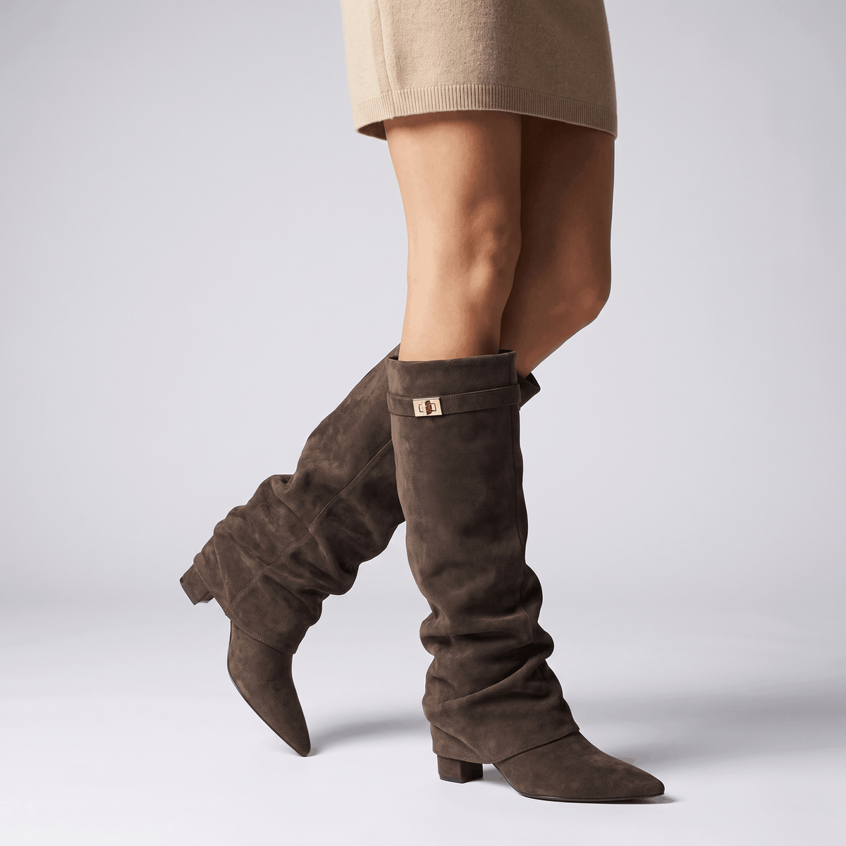 Dark brown slouchy fold-over boots worn with a skirt, showing the relaxed shaft