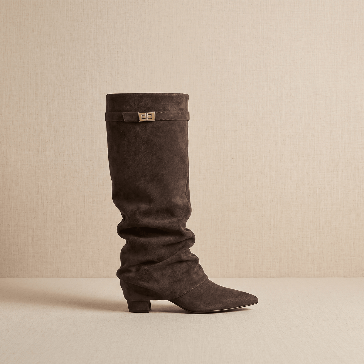 Dark brown fold-over knee-high boots shown from the side with pointed toes