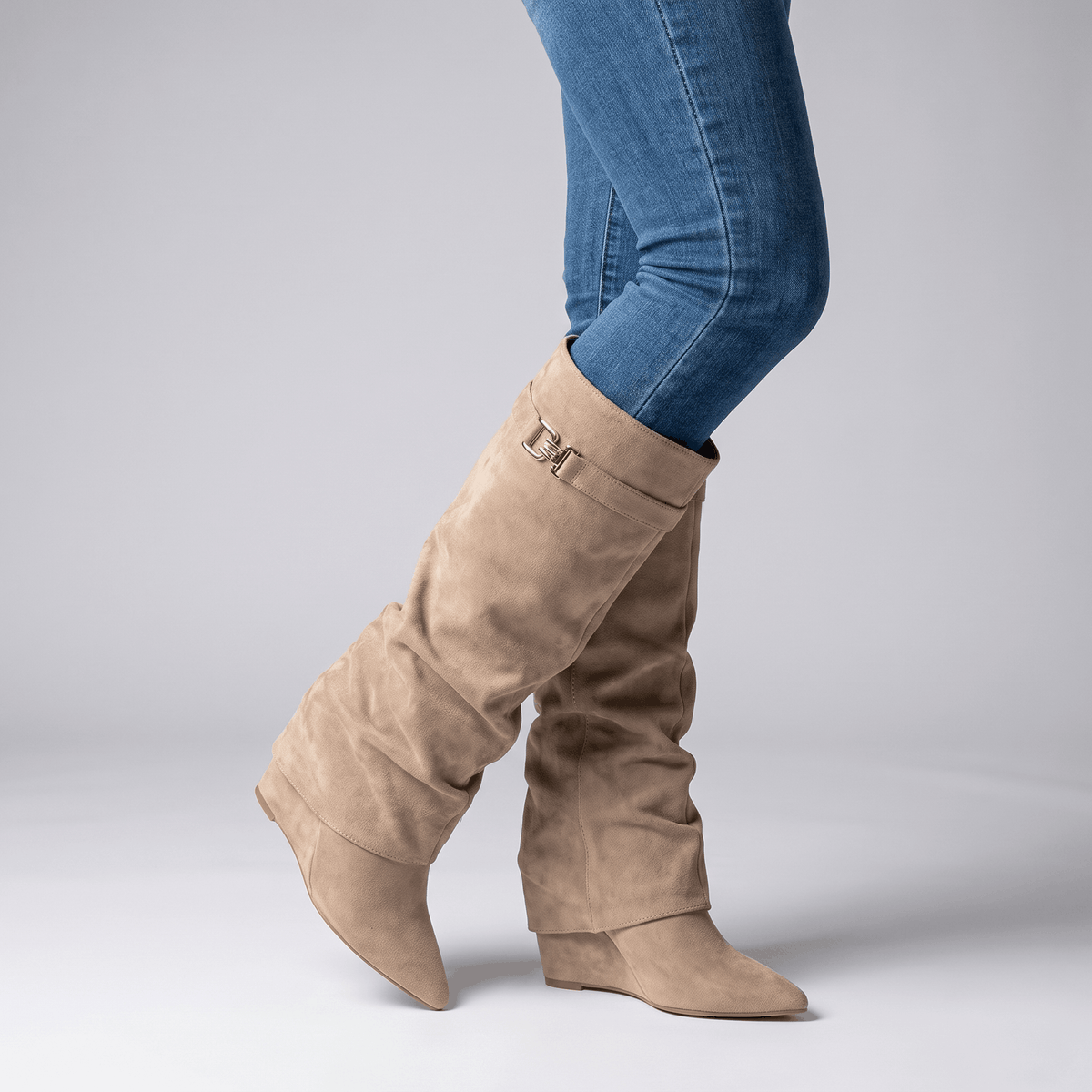 Beige knee-high fold-over boots worn with blue jeans