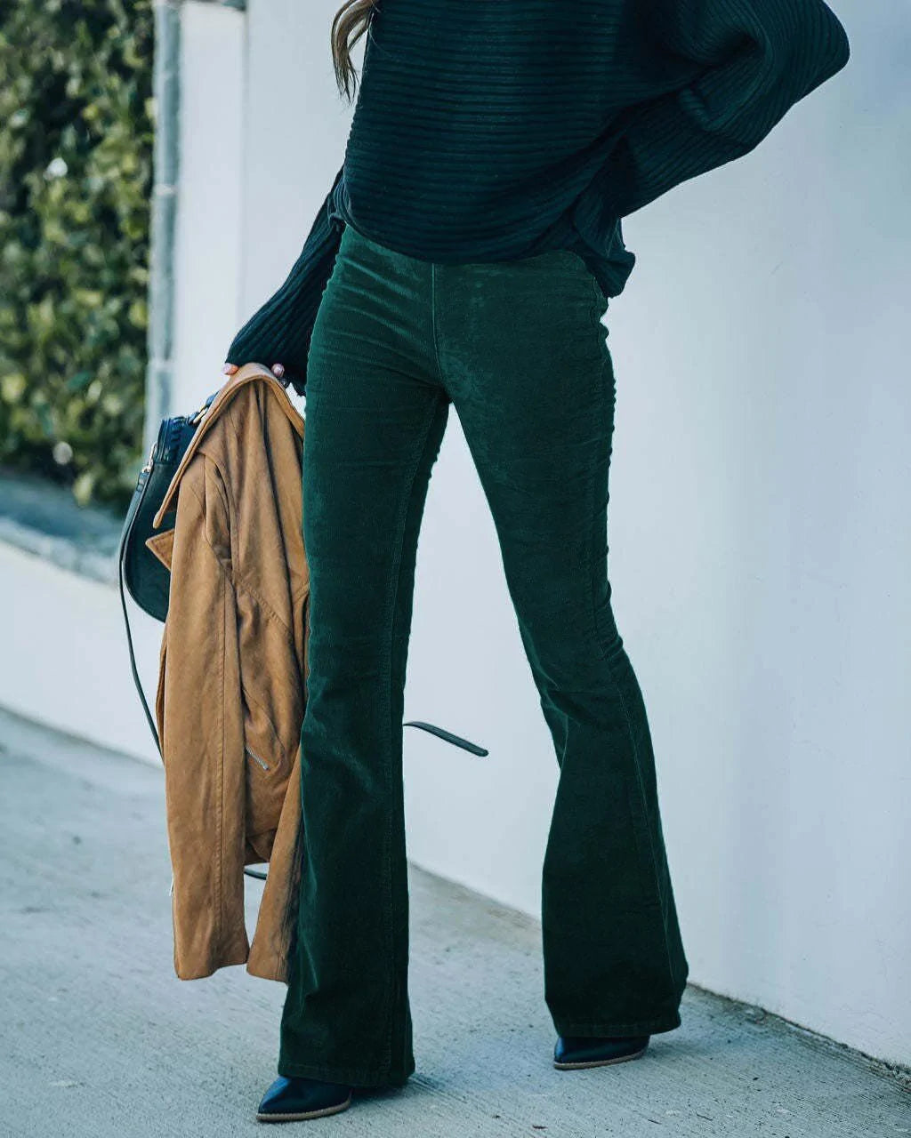 High-rise dark green corduroy flare pants with a smooth flat front and fitted silhouette.