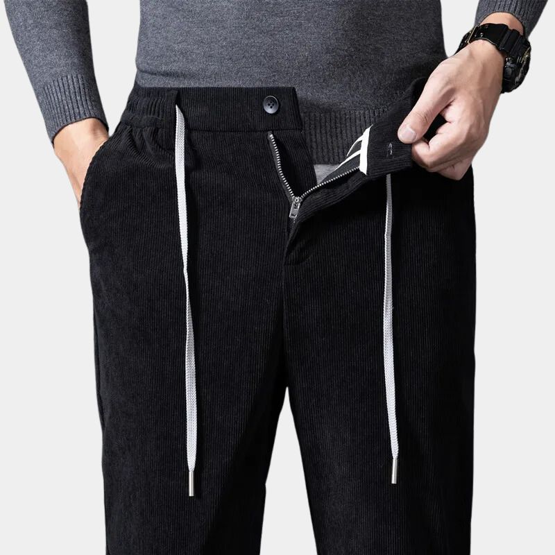 Black stretch corduroy pants featuring a ribbed texture, straight-leg cut, and an elastic drawstring waist.