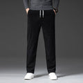 Black stretch corduroy pants featuring a straight-leg cut, elastic drawstring waist, and ribbed texture.