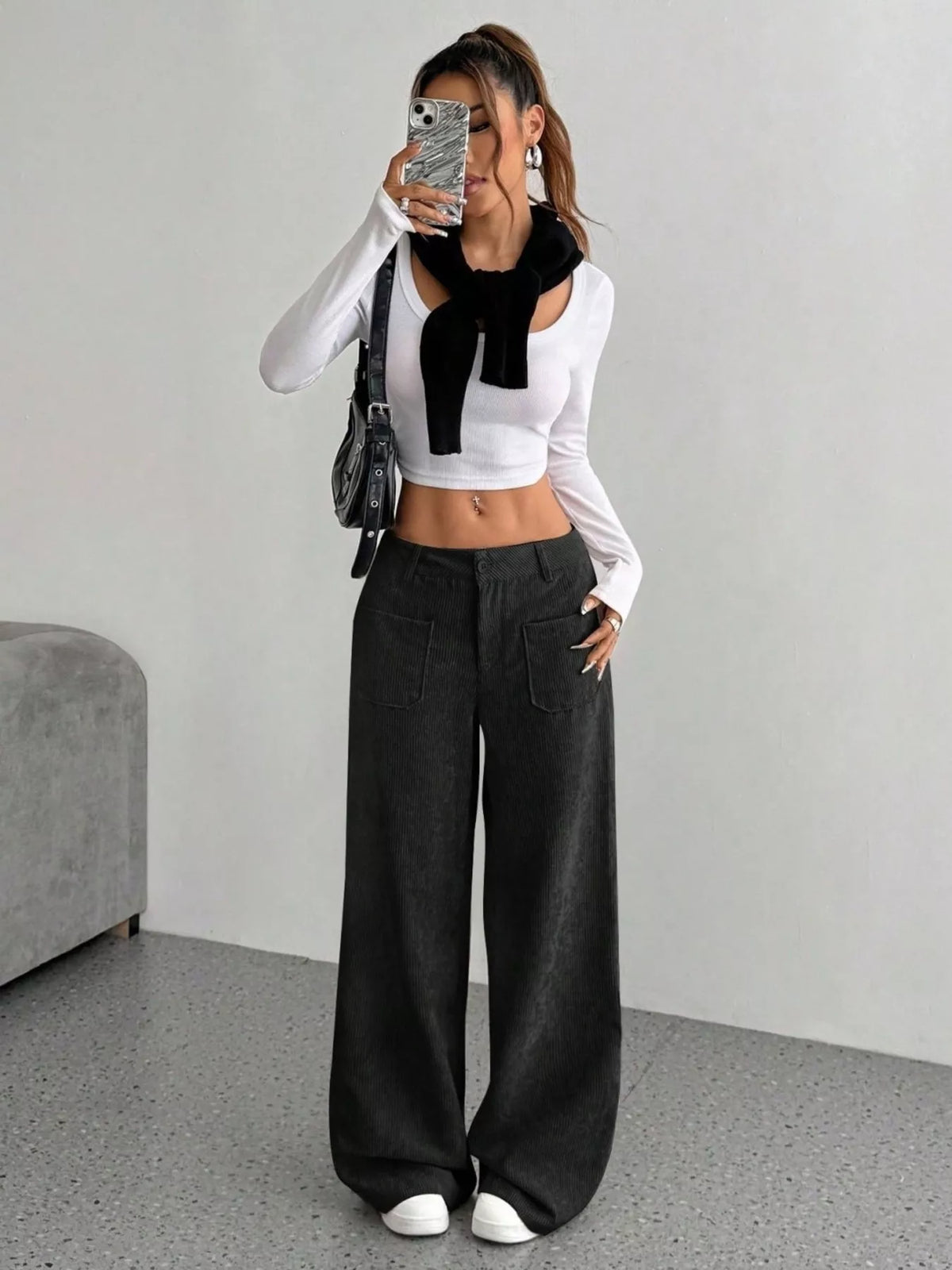 Black stretch corduroy wide-leg pants featuring front patch pockets, a mid-rise waist, and a clean button-zip fly.
