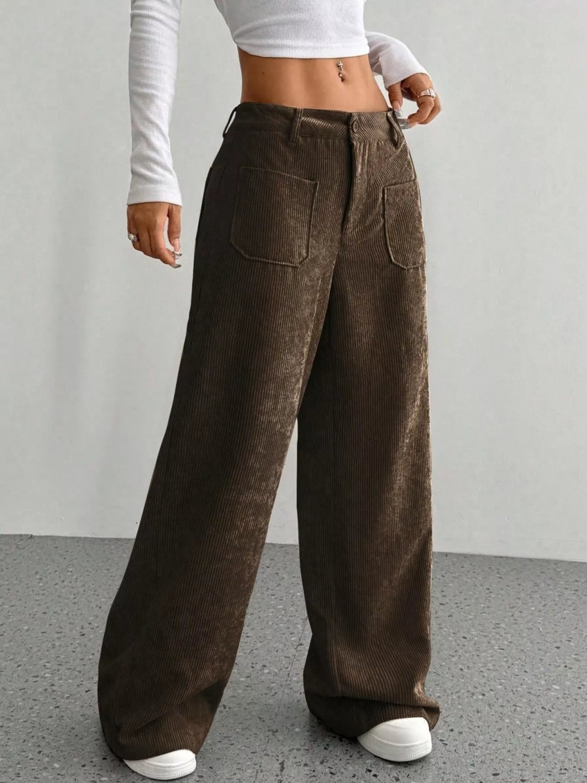 Brown wide-leg stretch corduroy pants featuring front patch pockets, a button-zip fly, and a relaxed floor-length fit.