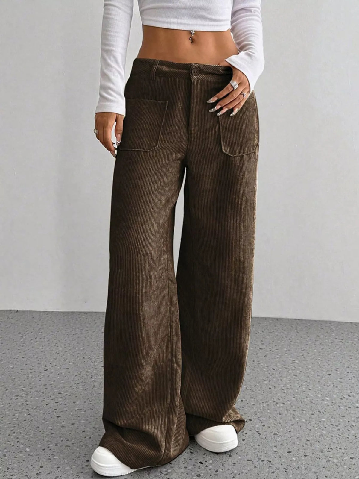Dark brown stretch corduroy wide-leg pants featuring front patch pockets, a button-zip fly, and a relaxed floor-length fit.