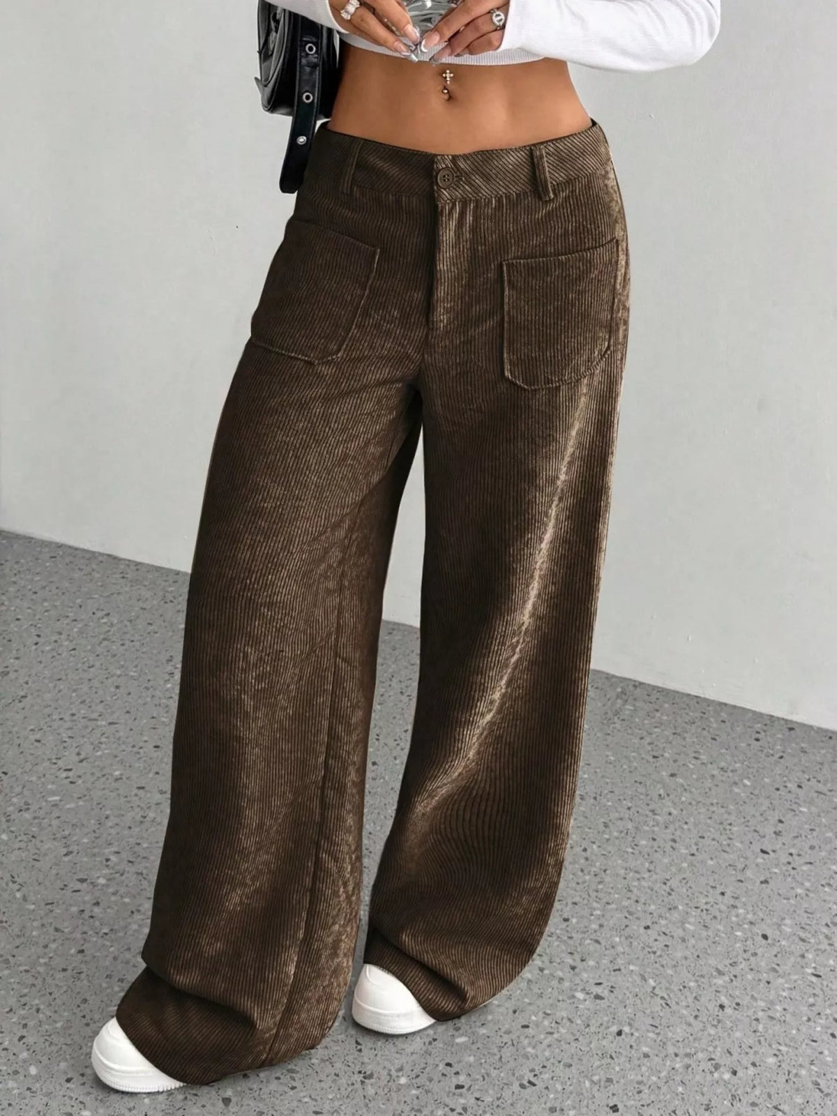 Brown stretch corduroy wide-leg pants featuring front patch pockets, a button-zip fly, and a relaxed, floor-length fit.