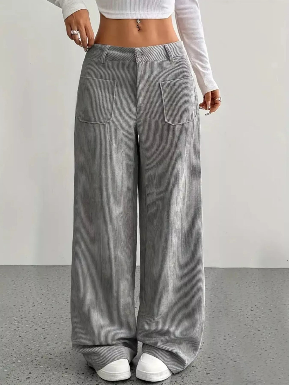 Gray wide-leg corduroy pants featuring front patch pockets, a button-zip fly, and a relaxed, floor-length fit.