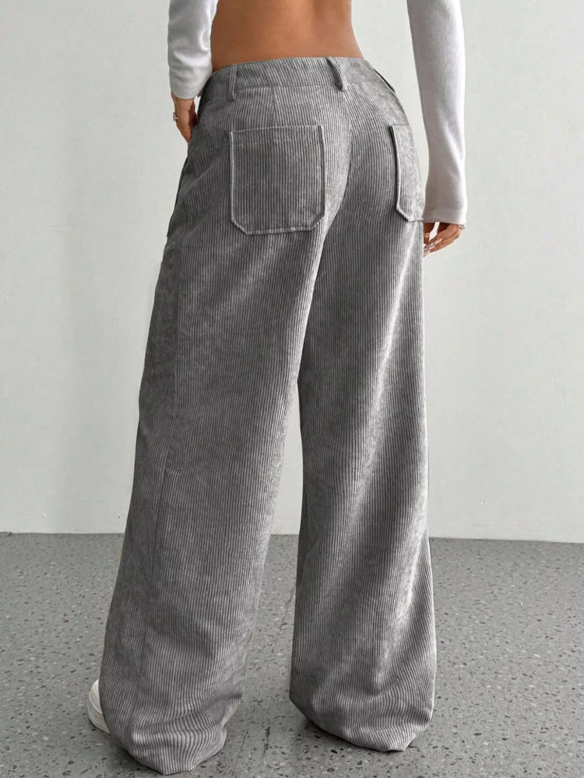 Gray wide-leg corduroy pants featuring a mid-rise waist, belt loops, and back patch pockets in a relaxed, floor-length fit.