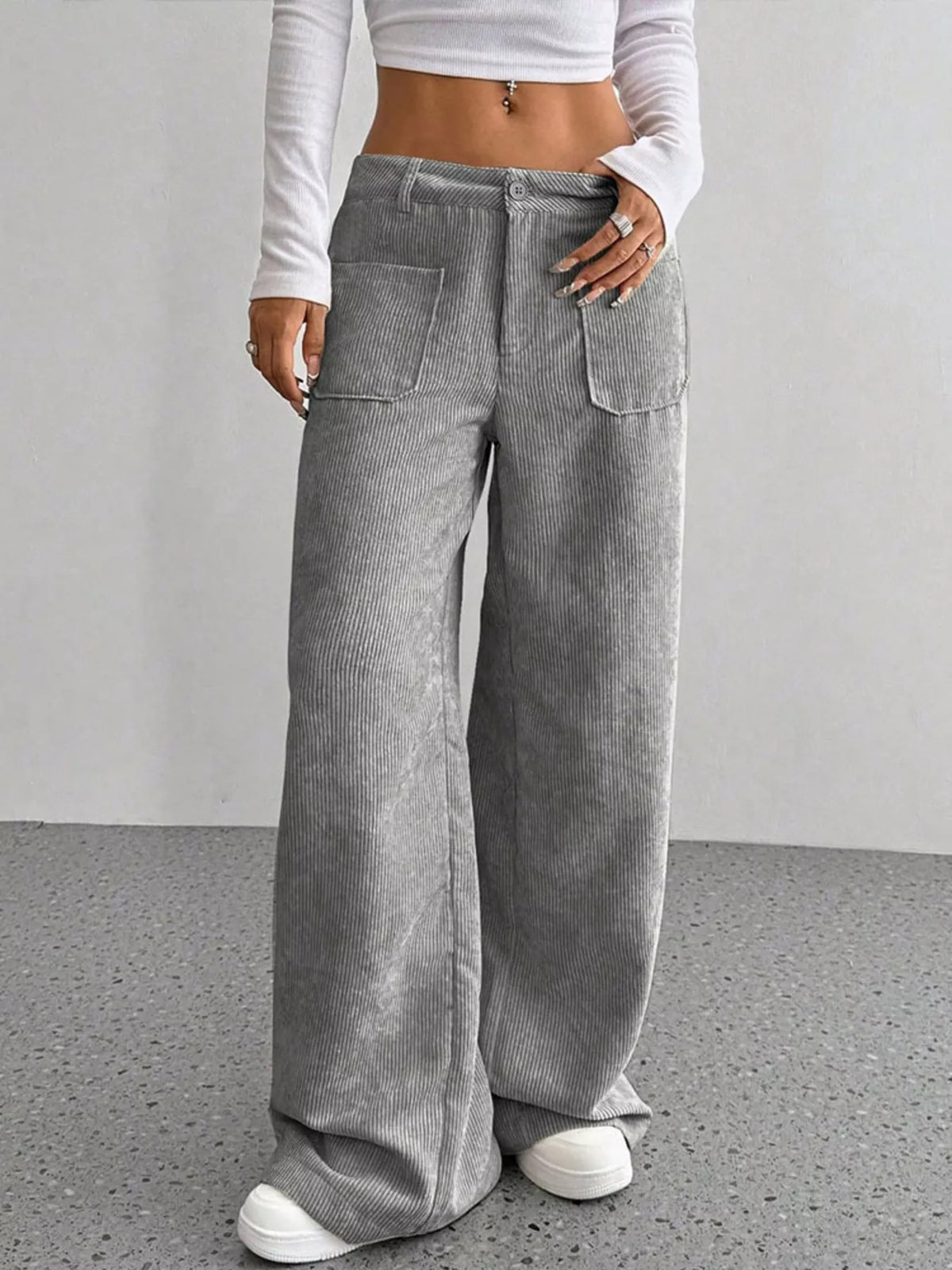 Gray wide-leg corduroy pants with front patch pockets, button-zip fly, and a relaxed, floor-length fit.