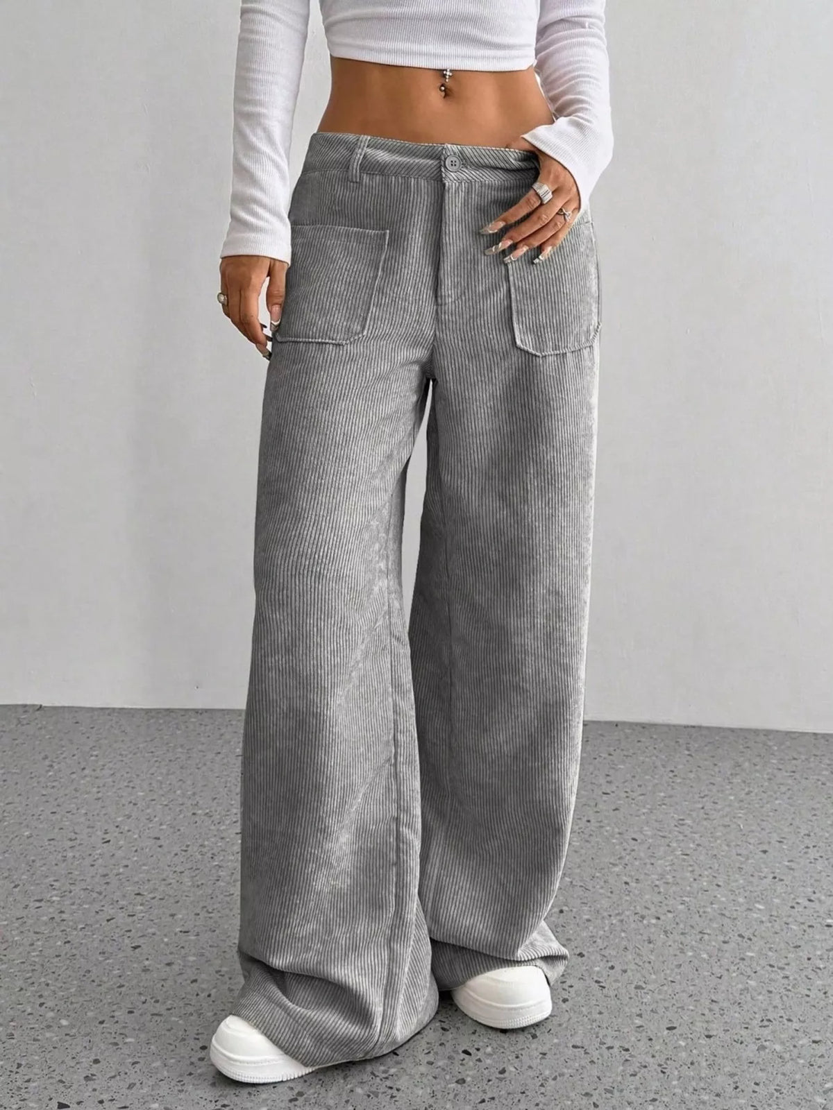 Gray wide-leg corduroy pants with front patch pockets, button-zip fly, and a relaxed, floor-length fit.