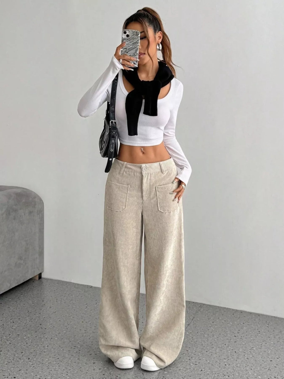 Beige stretch corduroy wide-leg pants featuring front patch pockets and a mid-rise fit, styled with a white cropped top.