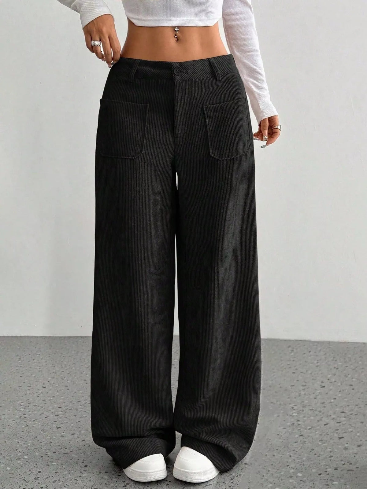 Black wide-leg corduroy pants featuring front patch pockets, a button-zip fly, and a relaxed, floor-length silhouette.