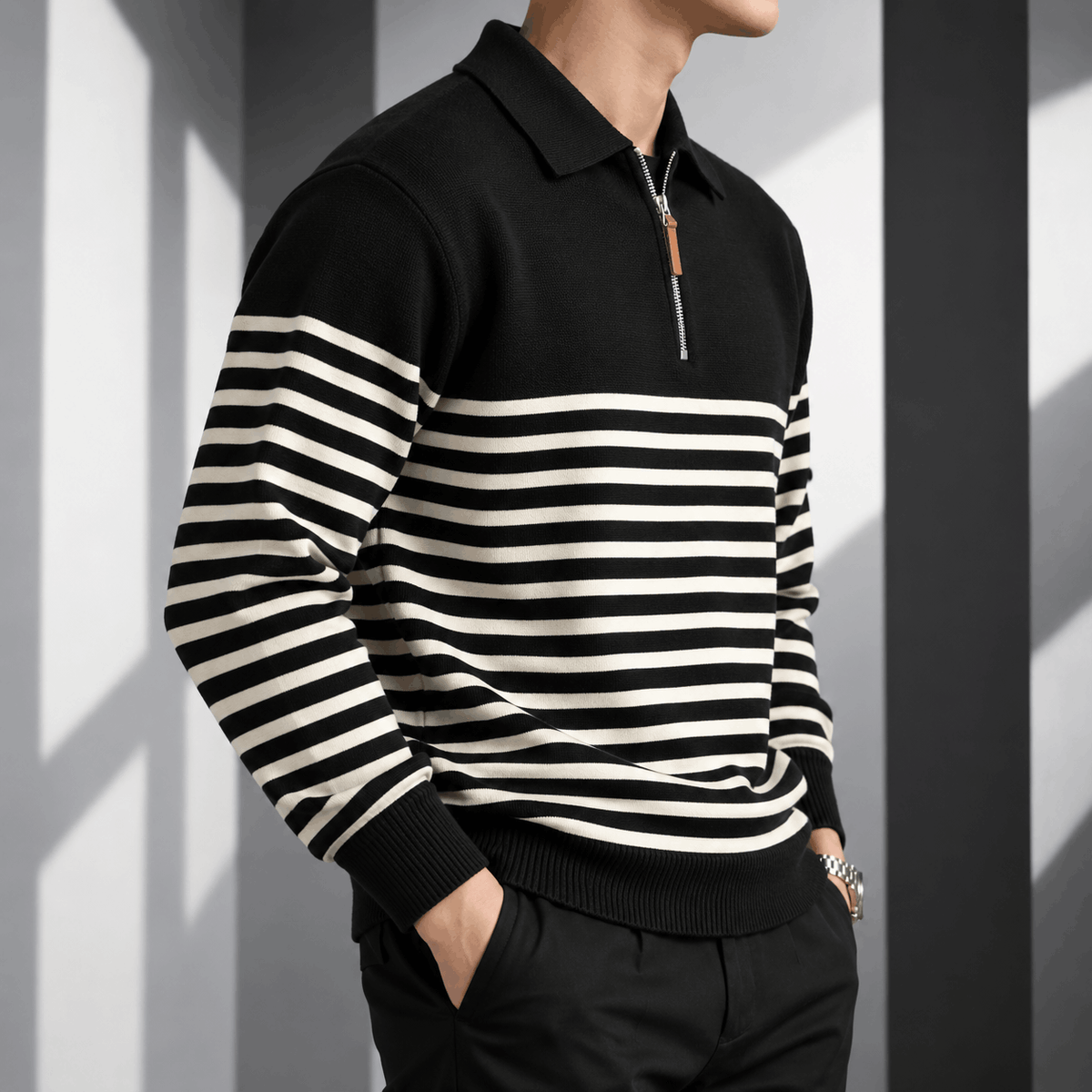 Black and cream striped quarter-zip polo worn by a male model, shown in a close-up view with the quarter-zip collar and contrast stripes.