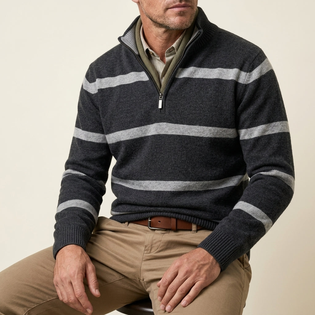 Man wearing a charcoal gray and white striped quarter-zip sweater while seated