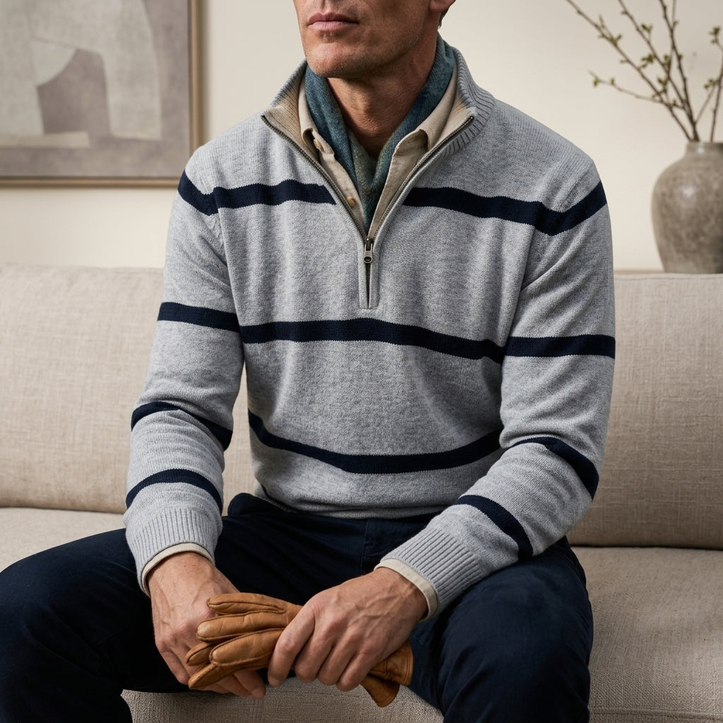 Man wearing a light gray and navy striped quarter-zip sweater while seated