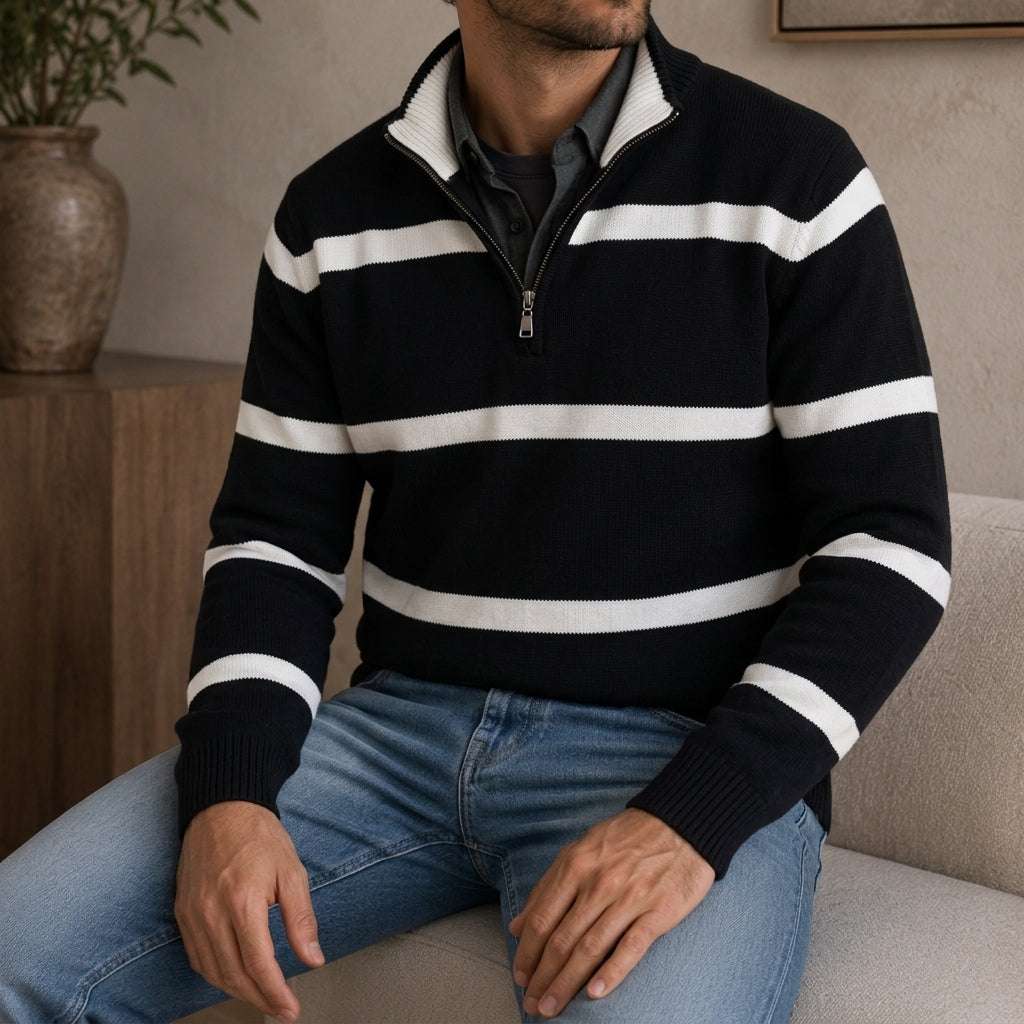 Man wearing a black and white striped quarter-zip sweater while seated