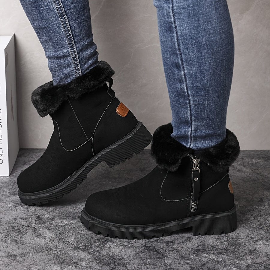 Black suede lug sole ankle boots for women with black fur-look collar, worn with jeans