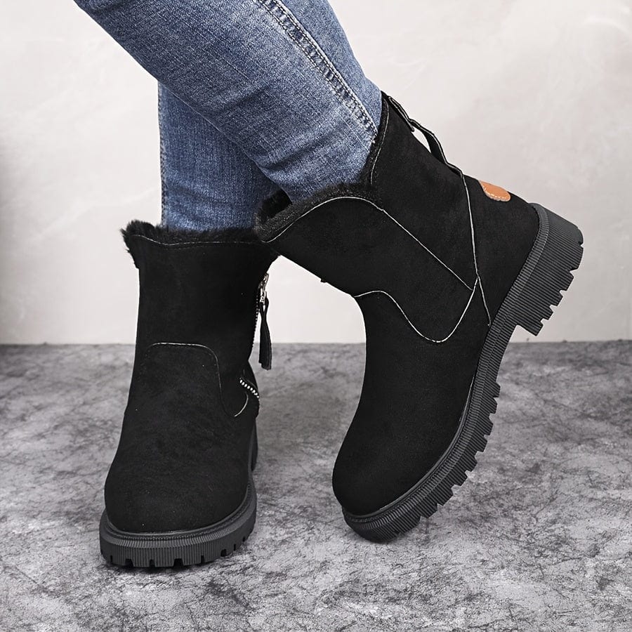 Black fleece-lined suede ankle boot for women showing the outer side zip and treaded lug sole