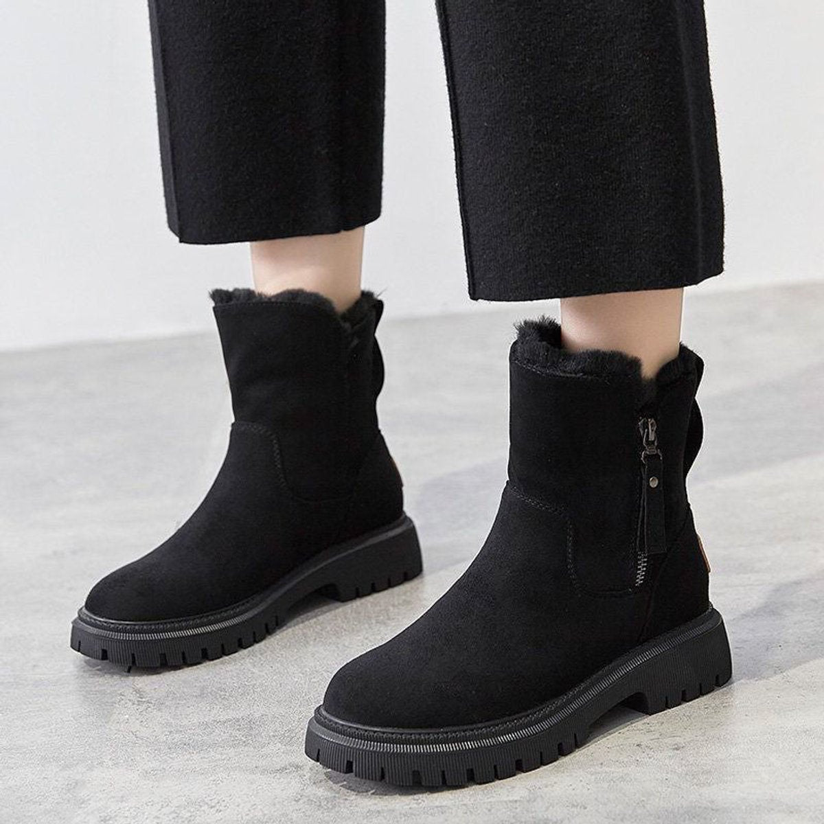 Black suede platform ankle boots for women with fleece-trimmed collar, worn with black trousers