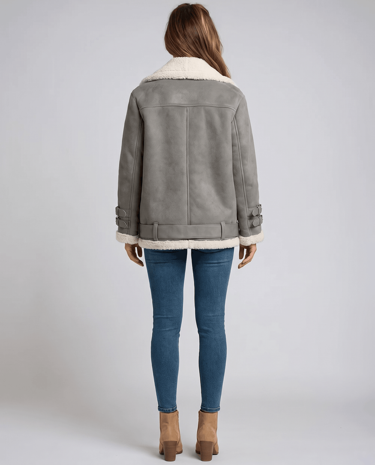 Gray suede aviator jacket with plush shearling lining, wide collar, and buckled hem details worn over blue jeans.