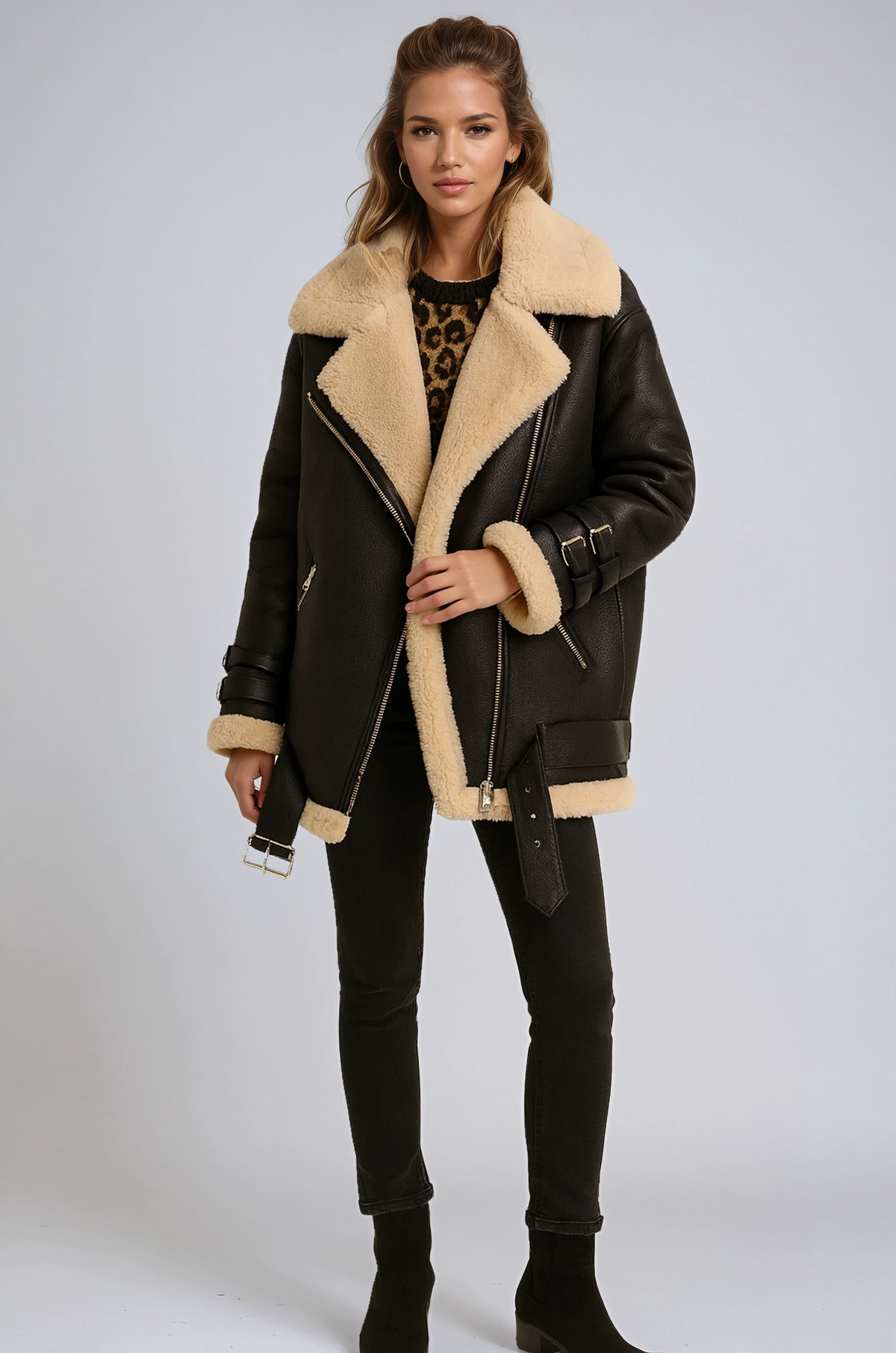 Black suede aviator jacket with plush cream shearling lining, wide collar, side zip closure, and buckle strap details.