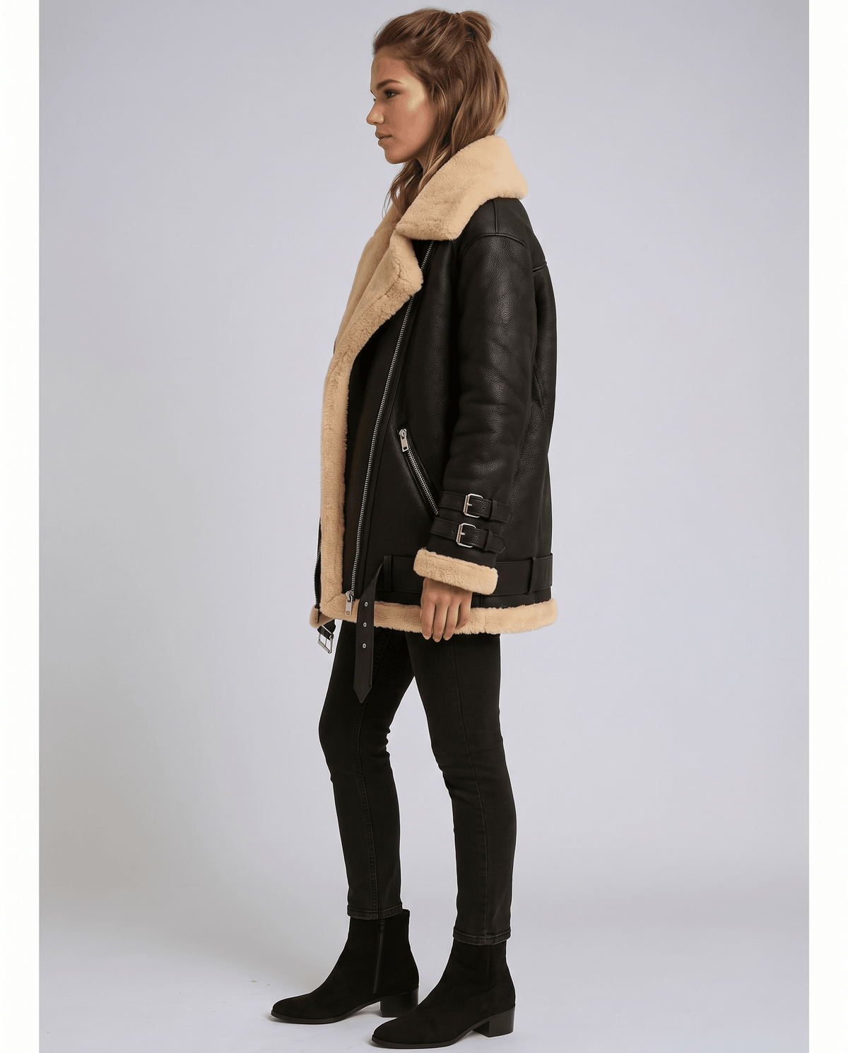 Black suede aviator jacket with plush cream shearling lining, wide collar, side zip closure, and buckled cuff straps.
