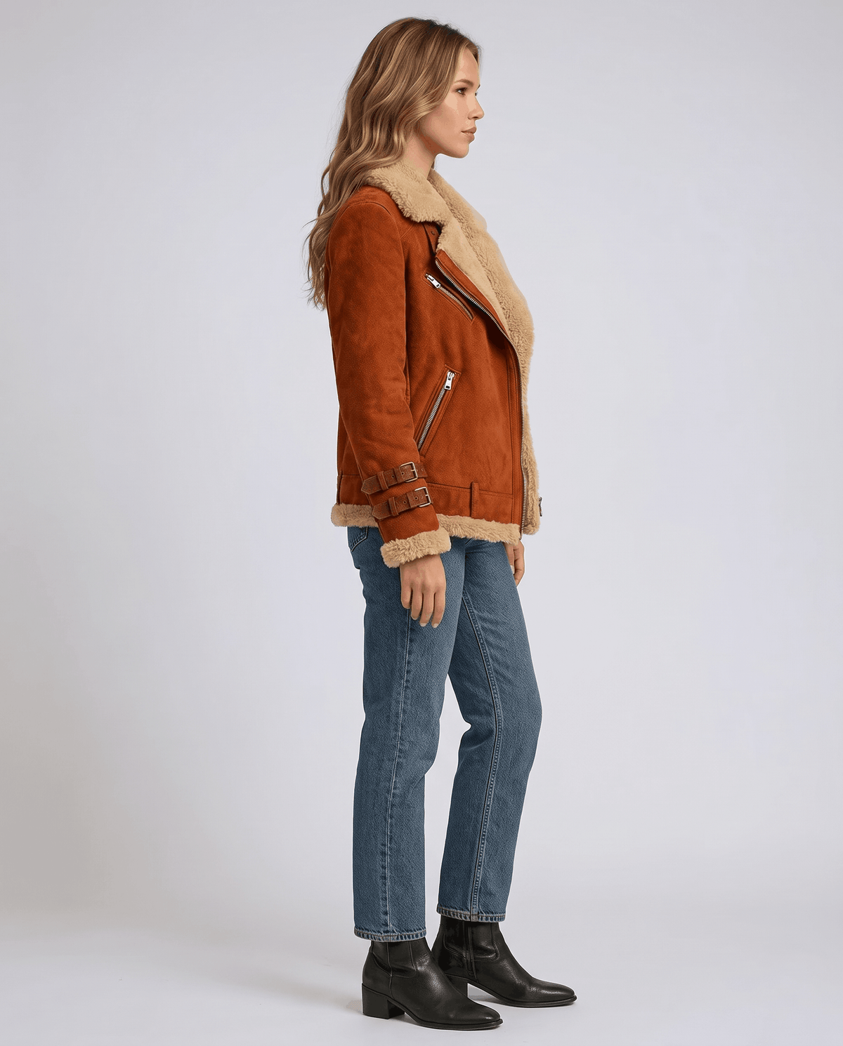 Orange suede aviator jacket with plush sheepskin lining, wide collar, side zip closure, and buckle waist details.