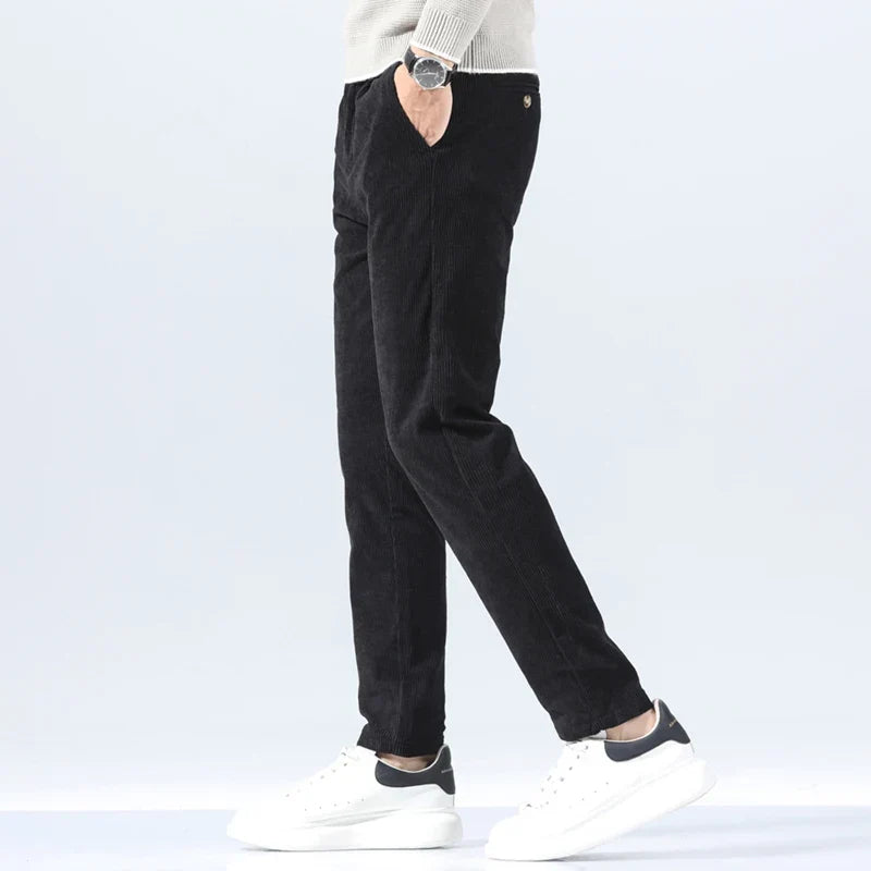 Black heavyweight corduroy pants in a straight-leg fit, featuring a clean zip-fly front and textured ribbed cotton fabric.