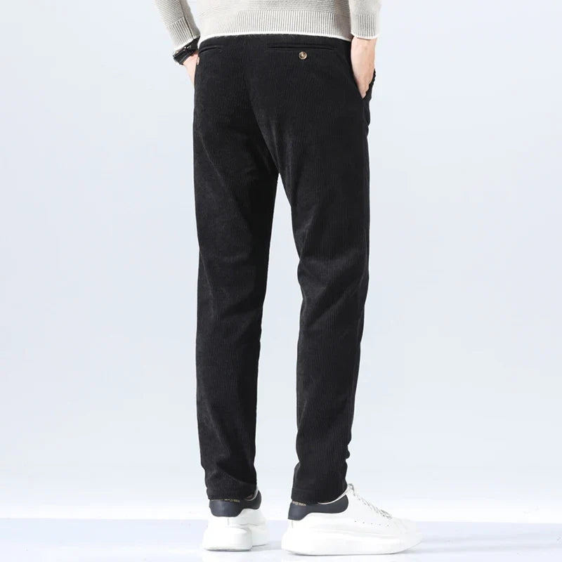 Black corduroy pants in a straight-leg fit, featuring a heavyweight ribbed texture and tailored back pockets.