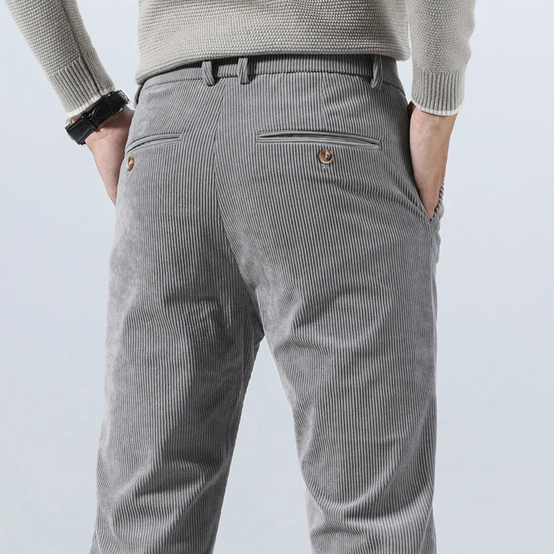 Gray straight-fit corduroy pants in heavyweight cotton with back welt pockets and button closures, worn with a textured sweater.