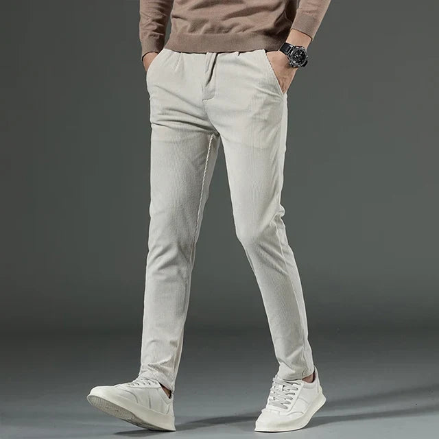 Light gray heavyweight corduroy pants in a straight-leg fit, featuring a clean zip-fly front and textured ribbed cotton fabric.