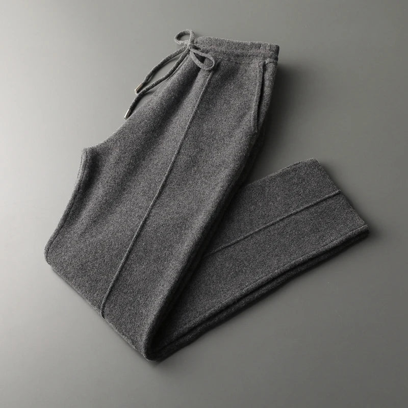 Dark gray wool knit trousers with a drawstring waist, tapered leg, and side pockets in a soft, relaxed silhouette.
