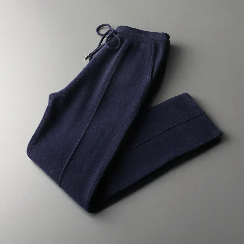 Navy blue wool knit trousers with a drawstring waist, side pockets, and a tapered leg silhouette.