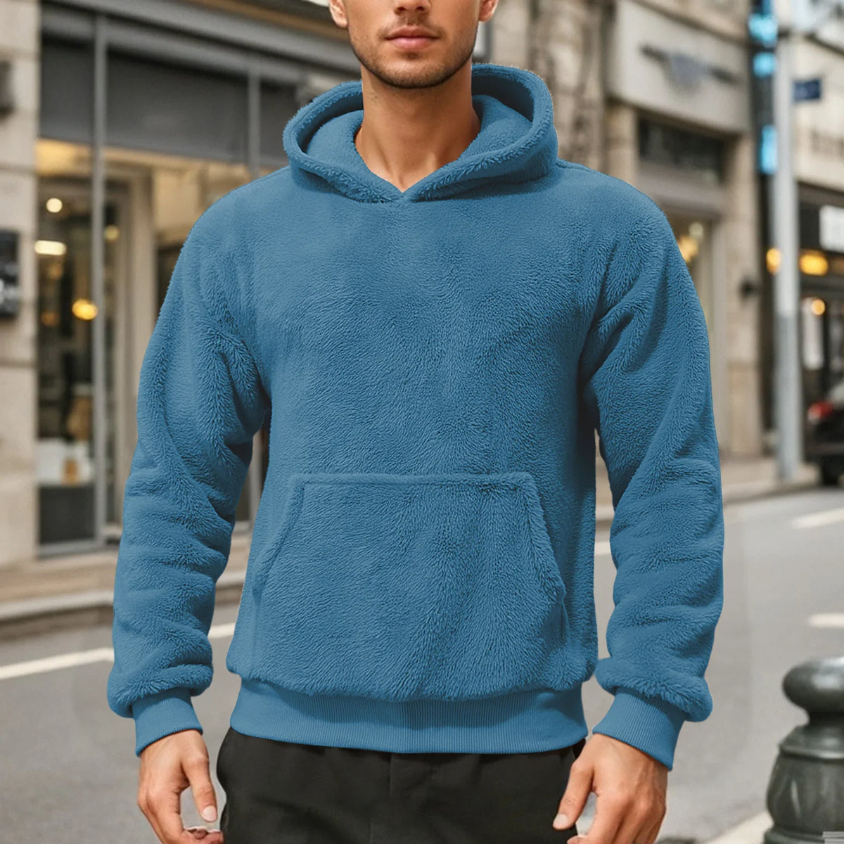 Blue teddy fleece hoodie worn by a male model, shown from the front with a kangaroo pocket.