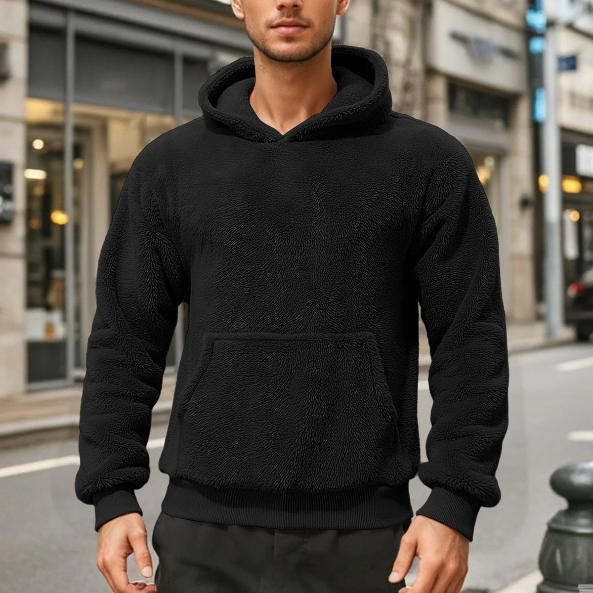 Black teddy fleece hoodie worn by a male model, shown from the front with a kangaroo pocket.