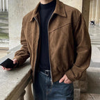 Brown suede bomber jacket with a point collar, zip-front closure, and elasticized hem worn over a black turtleneck.