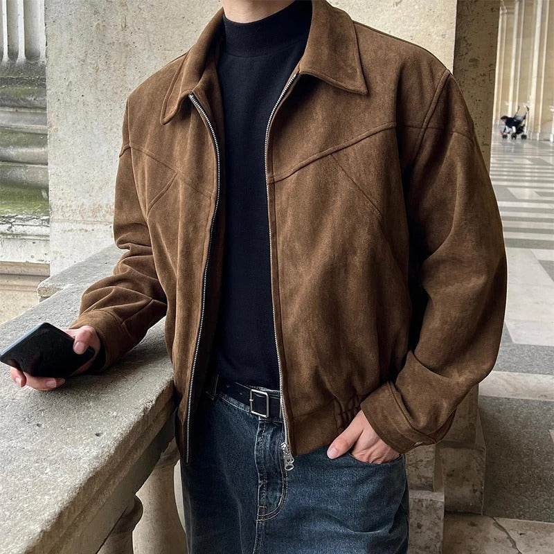 Brown suede bomber jacket with a point collar, zip-front closure, and elasticized hem worn over a black turtleneck.