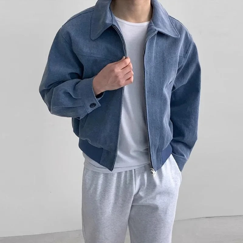 Blue suede bomber jacket with a point collar, zip-front closure, and buttoned cuffs in a relaxed, tailored fit.
