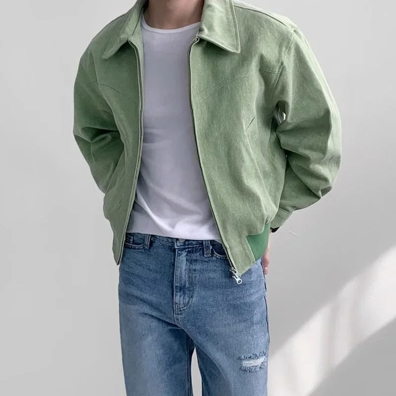 Sage green suede bomber jacket with a point collar, zip-front closure, and elasticized hem worn over a white tee.