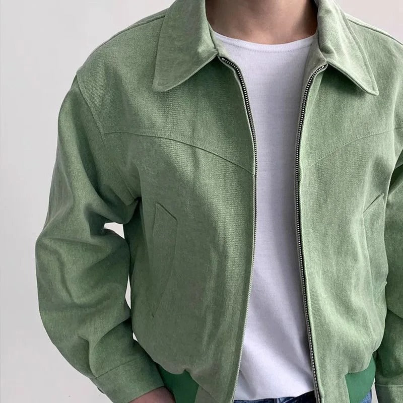 Sage green suede bomber jacket with a point collar, zip-front closure, and tailored fit over a white tee.