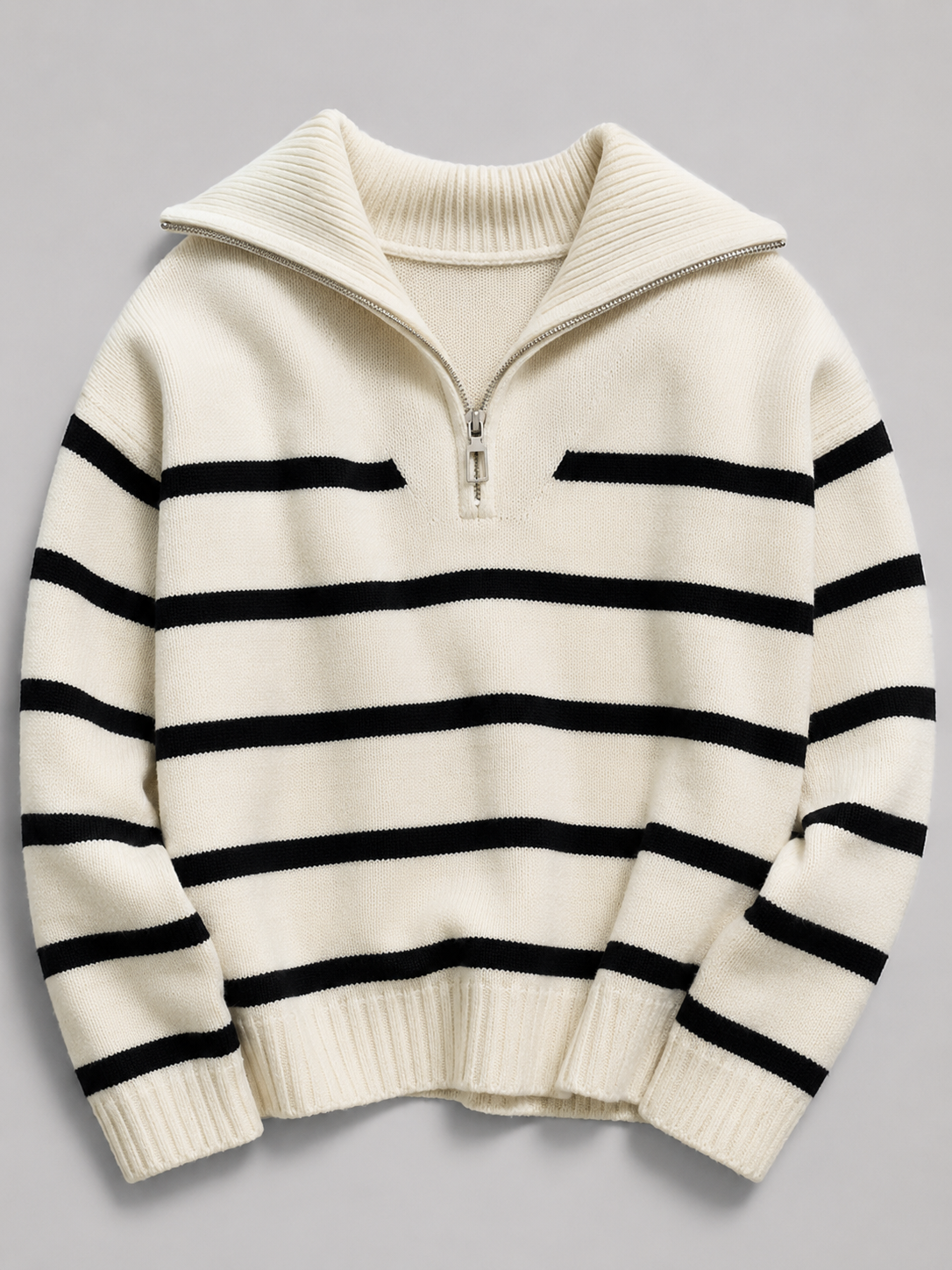 Mid-weight cream knit sweater with black stripes, half-zip stand collar, drop shoulders, and ribbed cuffs.