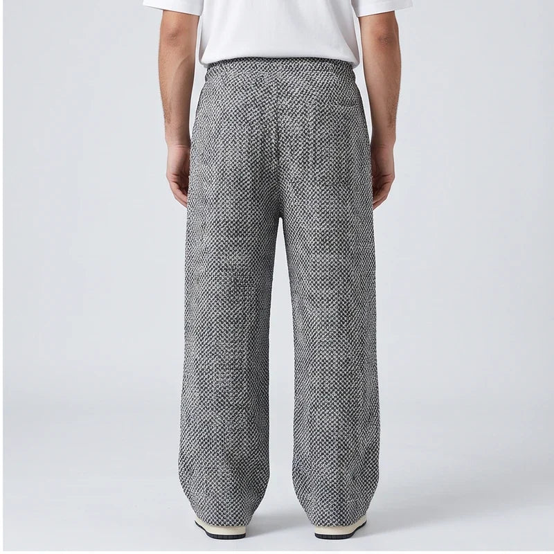 Men’s wide-leg tweed sweatpants in a gray herringbone wool blend, featuring a high-waisted fit and elastic waistband.