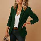 Dark green tailored blazer with notched lapels and a structured, fitted silhouette worn over a white v-neck top.