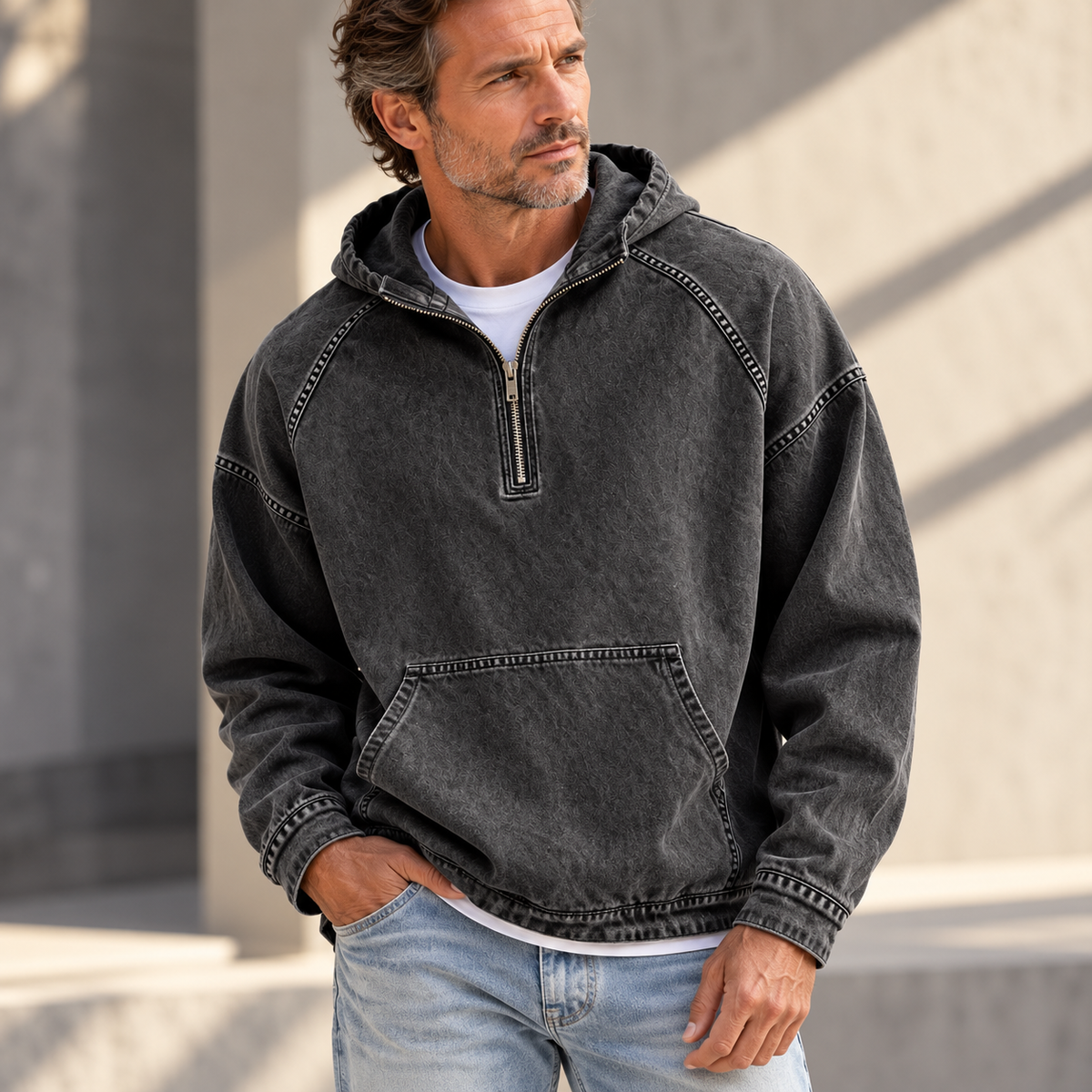 Black washed half-zip hoodie worn by a male model, featuring raglan sleeves and a kangaroo pocket.