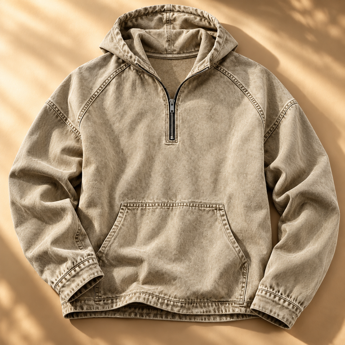 Beige washed half-zip hoodie shown from the front, highlighting the raglan sleeves and kangaroo pocket.