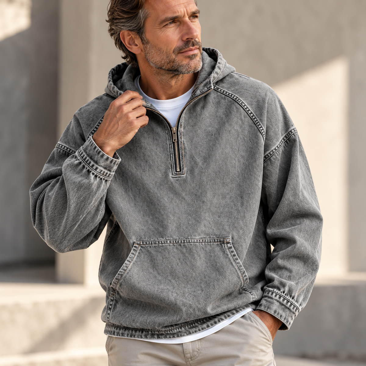 Gray washed half-zip hoodie worn by a male model, featuring raglan sleeves and a kangaroo pocket.